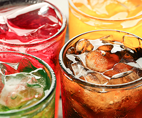 Close-up of colorful beverages with ice, representing flavor enhancer products - Chemical Market