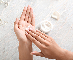 Applying emollient cream to hands for skin softening and moisture retention
